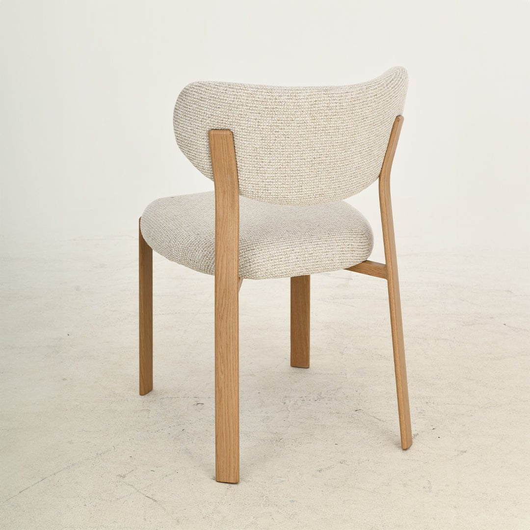 Witte eetkamerstoel met houtkleurige stoelpoten.